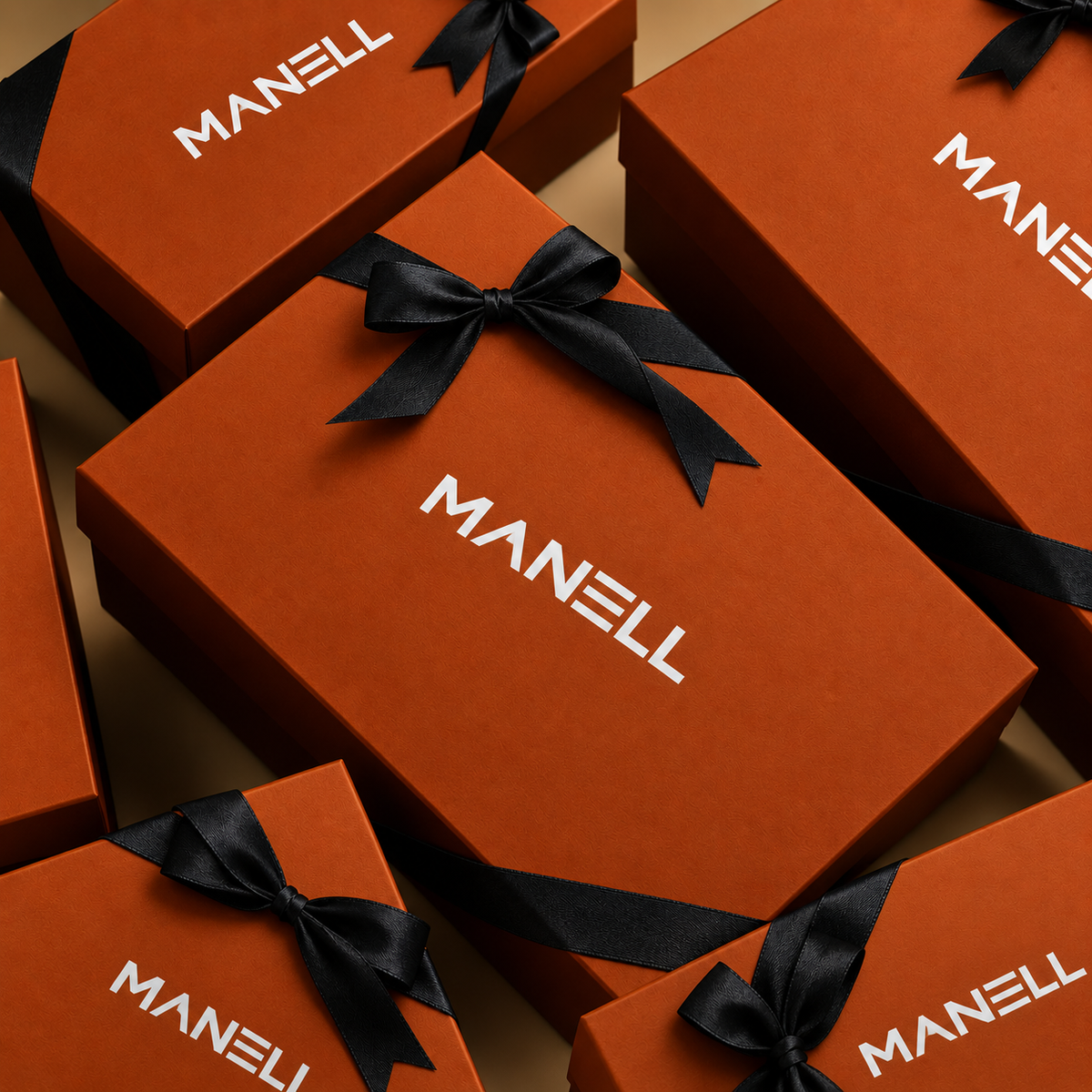 Multiple orange MANELL gift boxes arranged in a flat-lay pattern, each tied with a black ribbon.